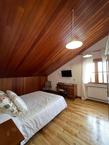 a bedroom with a bed and a wooden ceiling at Hotel Regueiro in Tox