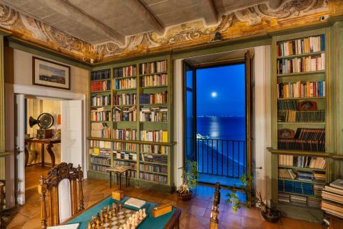 a library with bookshelves and a table in a room at Palazzo Suriano Heritage Hotel in Vietri sul Mare