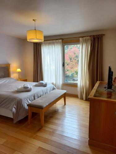 a bedroom with a bed and a large window at Departamento Centro San Martin de los Andes in San Martín de los Andes