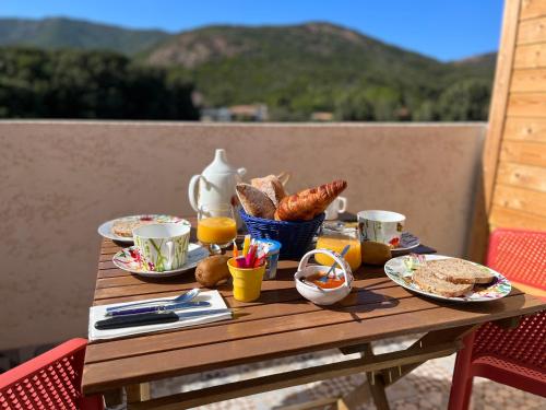 Résidence Casa TOGA في غاليريا: طاولة خشبية عليها اطعمة الافطار