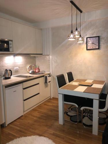 a kitchen with a table and chairs in a room at apartman Kraljevi čardaci Sadikovic sa garažom in Kopaonik