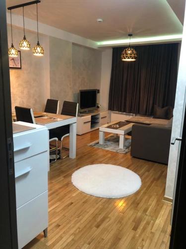a kitchen and living room with a desk and a couch at apartman Kraljevi čardaci Sadikovic sa garažom in Kopaonik