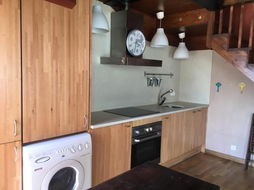 une cuisine avec une machine à laver et un évier dans l'établissement Casa de poble acollidora,amb llar de foc,, à Bourg-Madame