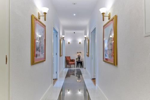 a hallway with white walls and paintings on the walls at Little Roos in Pula