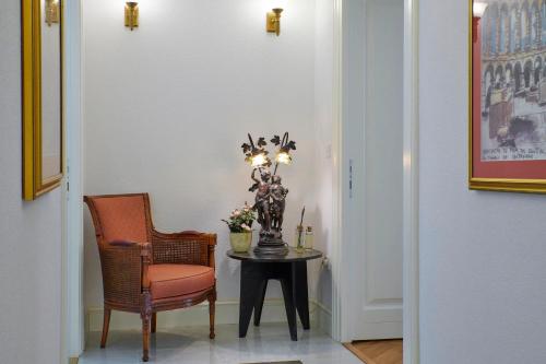 a hallway with a table and a chair and a vase with flowers at Little Roos in Pula