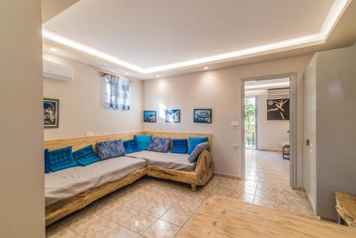 a large couch in a living room with blue pillows at Iniohos Zante Hotel & Suites in Argasi