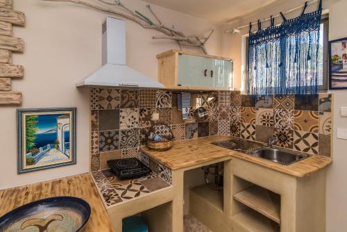 a kitchen with a sink and a counter top at Iniohos Zante Hotel & Suites in Argasi