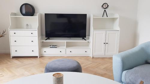 a living room with a television on a white entertainment center at Blick über Krems mit Gartenpavillon in Krems an der Donau