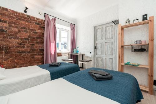 a bedroom with two beds and a brick wall at City Camp in Sortavala