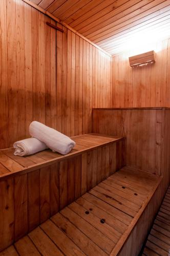 a wooden sauna with two towels sitting on the shelves at Victoria Village in Carilo