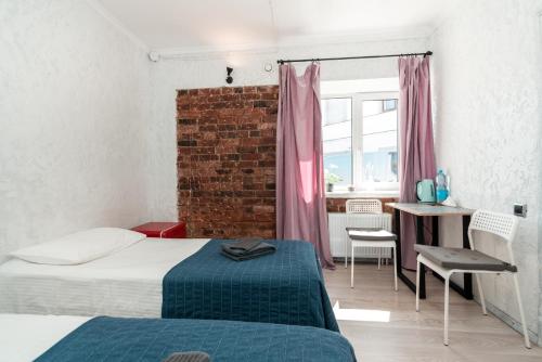 a bedroom with two beds and a brick wall at City Camp in Sortavala