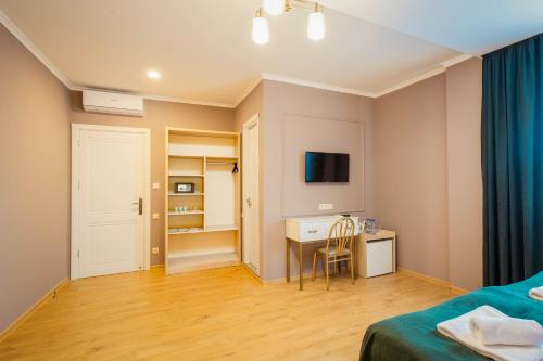 a bedroom with a bed and a desk and a tv at Galaktioni 22 in Tbilisi City