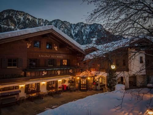 a large building with snow covered mountains in the background at Charmehotel Uhrerhof - Deur in Ortisei