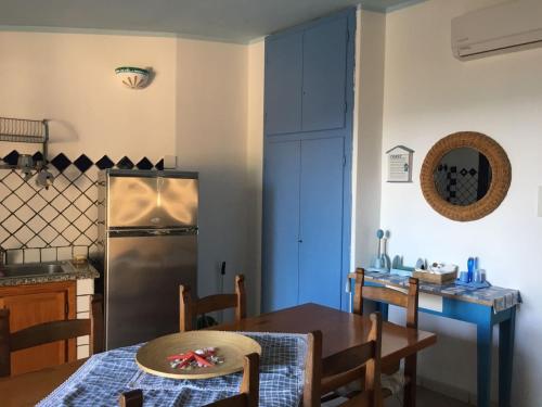 cocina con mesa y nevera de acero inoxidable en Villa Vera trifamigliare con ingresso diretto 20 mt al mare clima wi-fi bbq, en Cala Liberotto