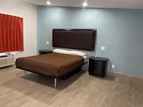 a bedroom with a bed with a large monitor on the wall at Executive Inn in Hobbs