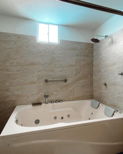 a white bath tub in a bathroom with a window at Hotel G Cartagena in Cartagena de Indias
