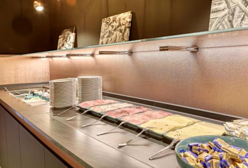 a buffet line with meat and plates of food at Kurpension Freudenstein in Bad Füssing