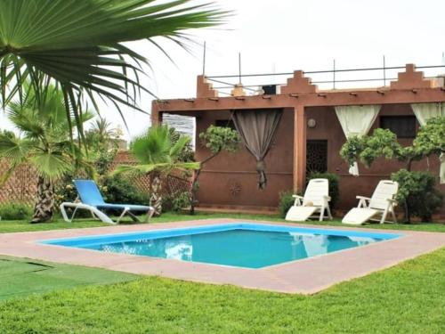 a swimming pool in the yard of a house at Riad Darga Rouge in Marrakesh