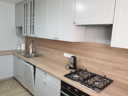 a kitchen with white cabinets and a stove top oven at Best Apartment Truskavets in Truskavets