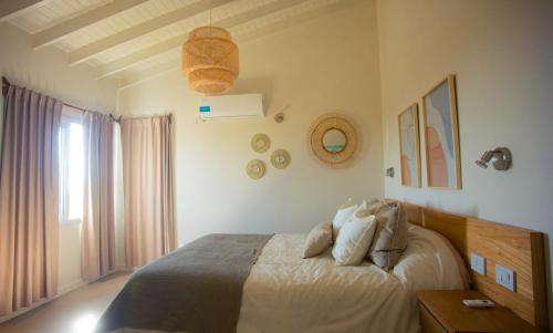 Amardecer - Casa Boutique في ميرلو: غرفة نوم بسرير ونافذة