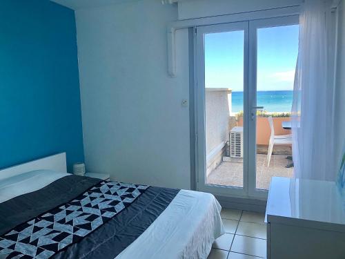 une chambre avec un lit et une vue sur l'océan dans l'établissement Barcaresa-Charmant T 2 vue mer pied dans l'eau, au Barcarès