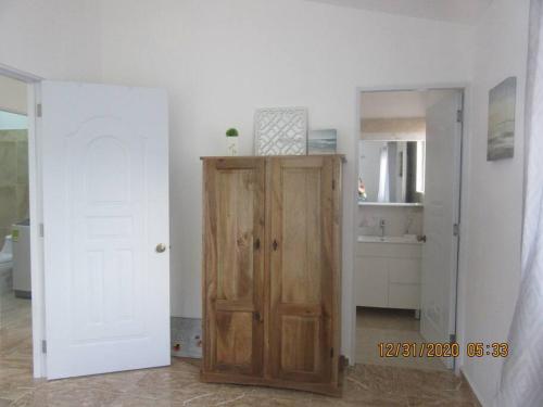 a kitchen with a wooden door in a room at Pelicano Tropical Paraiso Samana in Santa Bárbara de Samaná