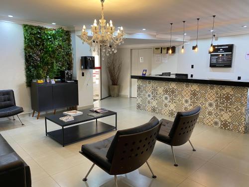 a living room with chairs and a coffee table at Hotel Diamante in Sao Paulo