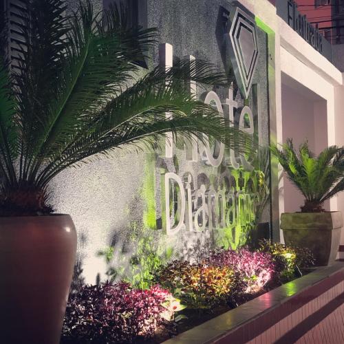 a sign on the side of a building with plants at Hotel Diamante in Sao Paulo