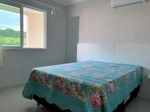 um quarto com uma cama com uma colcha em Apartamento aconchegante próximo a tudo em Piratuba Oeste Catarinense em Piratuba