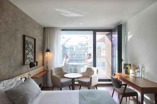 a hotel room with a bed and a table and chairs at Lux Lisboa Park in Lisbon