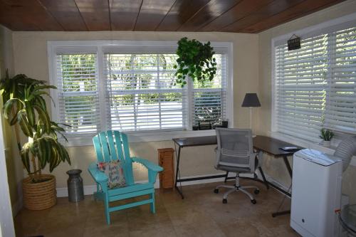 ウェストパームビーチにあるIn the heart of West Palm Beach, pets welcomeのデスク、椅子2脚、窓が備わる客室です。