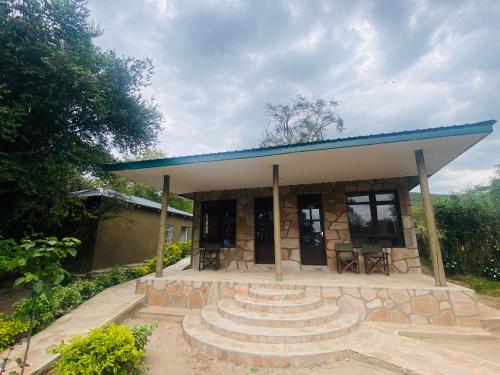 a small building with a blue roof and stairs at Oldarpoi Wageni Camps in Keekorok