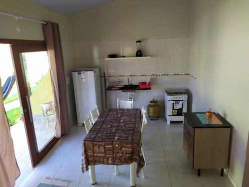 eine kleine Küche mit einem Tisch und einem Herd in der Unterkunft Casa em PIPA 2 quartos 103 in Pipa