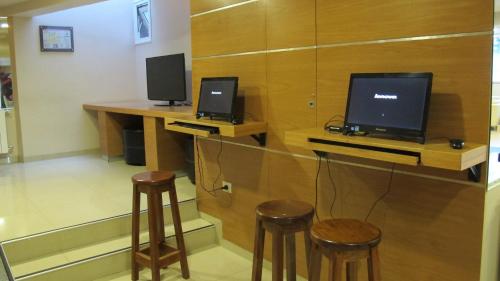 a room with two monitors on a desk with stools at Cambria in San Carlos de Bariloche