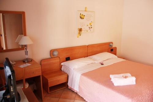 a bedroom with a bed and a desk and a bed sidx sidx sidx at Albergo Al Viale in Trieste