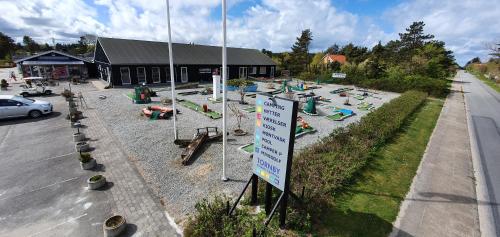 a parking lot with a sign in front of a building at Tornby Strand Camping Cottages in Hirtshals
