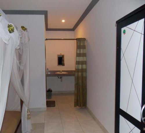 a bathroom with a sink and a shower curtain at Five Time Home Stay in Gili Islands