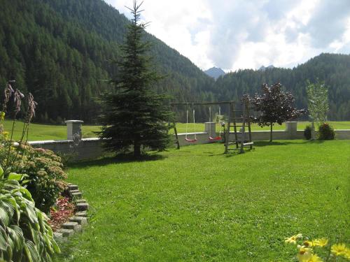a park with a pine tree and a playground at ban Kneissl`s in Umhausen