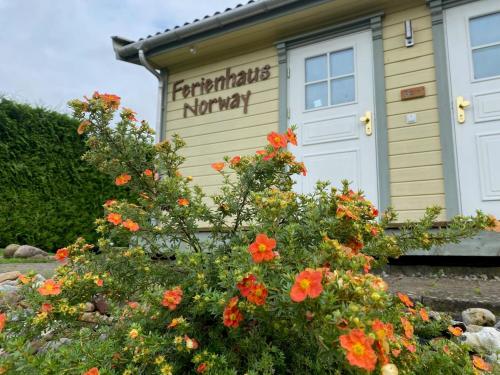 a sign on the side of a building with flowers at Ferienhaus Norway in Wittenbeck