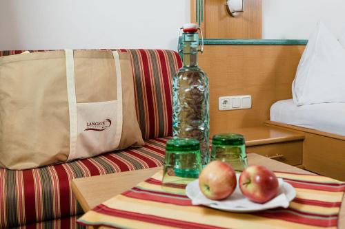 a table with two apples and a bottle on it at Hotel Langeck in Maria Alm am Steinernen Meer