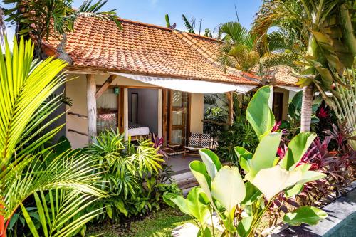 a house in the middle of a garden at Seaside Tribe - Boutique Surf Stay & Retreat in Tanah Lot