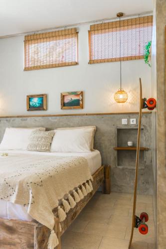 a bedroom with a bed with a wooden frame at Seaside Tribe - Boutique Surf Stay & Retreat in Tanah Lot