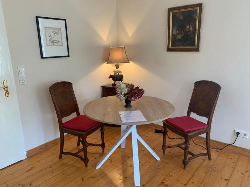 a table with two chairs and a vase of flowers on it at Forsthaus in Waldhessen in Bauhaus