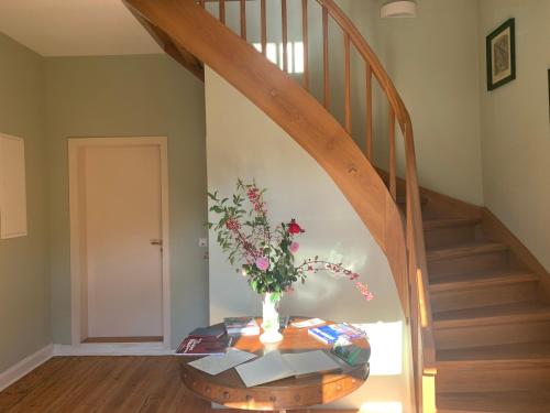 a staircase with a vase of flowers on a table at Forsthaus in Waldhessen in Bauhaus