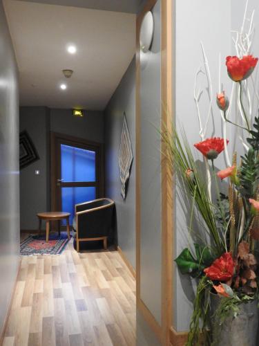 a hallway with red flowers on the wall at Au Bon Gîte in Senones