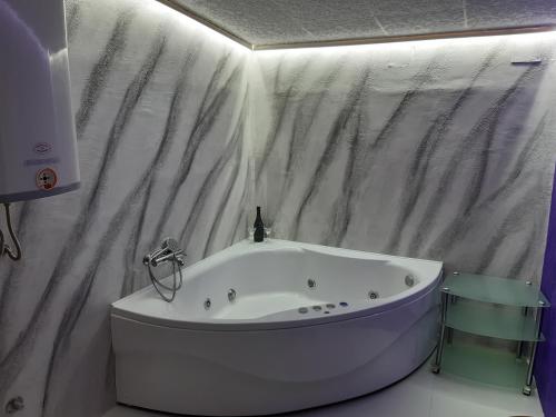 a white tub in a bathroom with a shower curtain at Djakuzi Viktorija in Belgrade