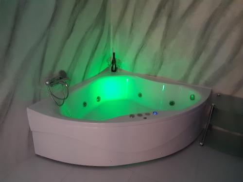 a bathroom with a green bath tub in a room at Djakuzi Viktorija in Belgrade