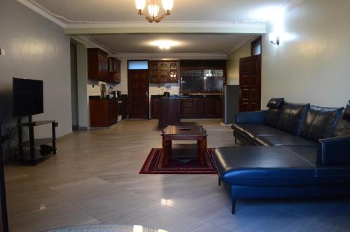 坎帕拉的住宿－Munyonyo Heights Apartments，客厅配有沙发和桌子