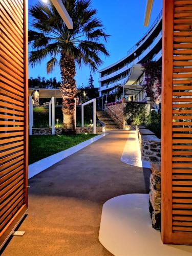a palm tree in front of a building with a driveway at Marmari Bay Hotel in Marmarion