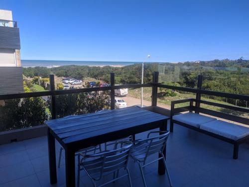 una mesa azul y sillas en un balcón con vistas en Linda Bay 202 en Mar de las Pampas